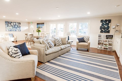 a living room with couches and chairs and a rug